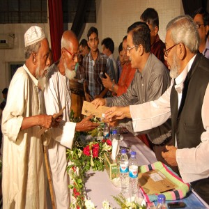 ছাত্রবৃত্তি, মুক্তিযোদ্ধা অনুদান, সেলাই মেশিন বিতরণ অনুষ্ঠান ২০১২ উপলক্ষে মুক্তিযোদ্ধাদের মাঝে অনুদানের অর্থ বিতরণ করছেন জনাব জাহাঙ্গীর কবির নানক, স্থানীয় সরকার প্রতিমন্ত্রী ও জনাব আজিজুর রহমান, প্রশাসক, জেলা পরিষদ, মৌলভীবাজার   